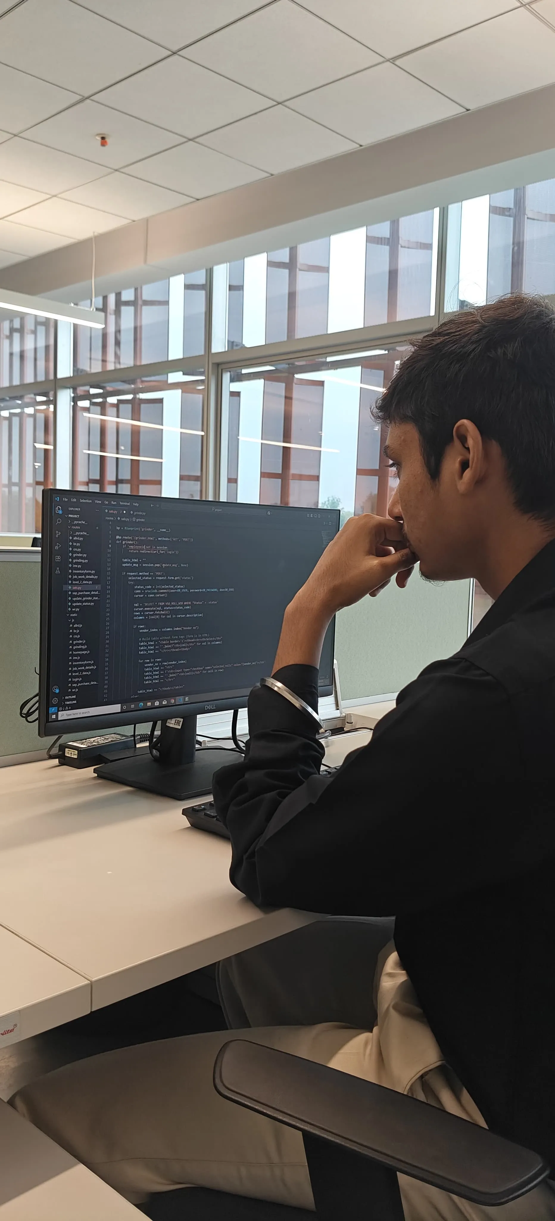 Kartik reviewing Flask code for the roll shop system at his desk at JSW Steel